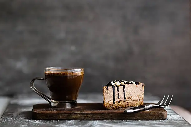 Photo of Vegan chocolate mousse cake and coffee on a stone background