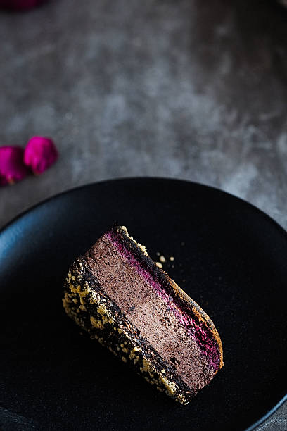 istock Dark chocolate cake cut with rose on  black plate 629079642