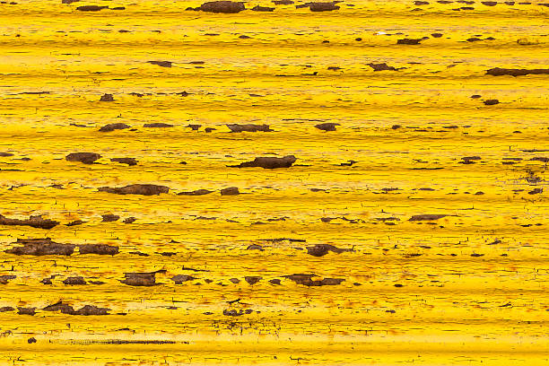 Rusty yellow paint on old fence stock photo