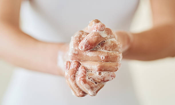 Keep clean and safe from germs Closeup shot of a woman washing her hands with soap hygiene stock pictures, royalty-free photos & images