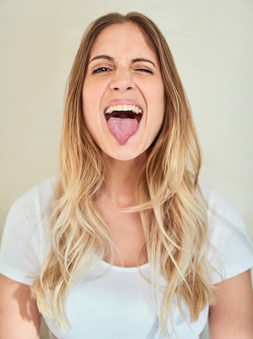 Portrait of an attractive young woman sticking out her tongue