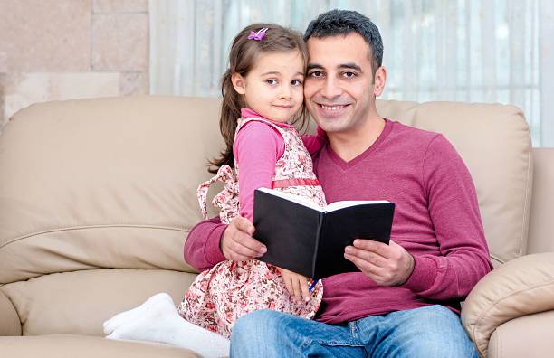 istock Little Girl And Father Reading Book 629100234