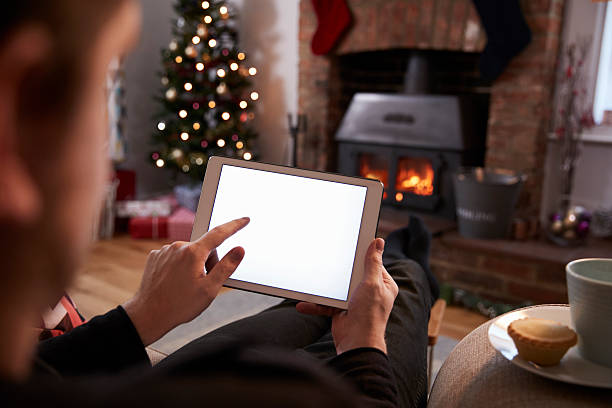 istock Man Using Digital Tablet In Room Decorated For Christmas 629113224