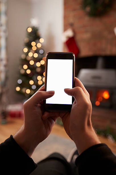 istock Man Using Mobile Phone In Room Decorated For Christmas 629113252