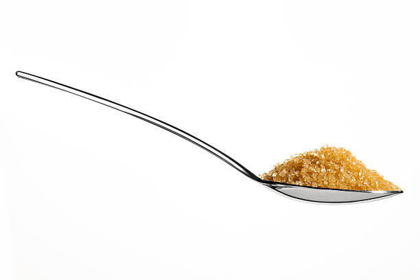 Brown sugar on teaspoon stock photo