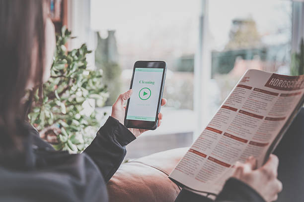 istock Woman Using Home Robot Cleaning App on Mobile Phone 629129694