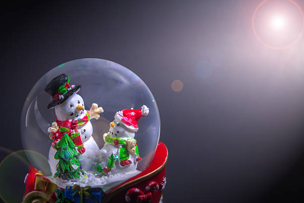 istock Christmas snow globe with snowman with len flare effect 629129956