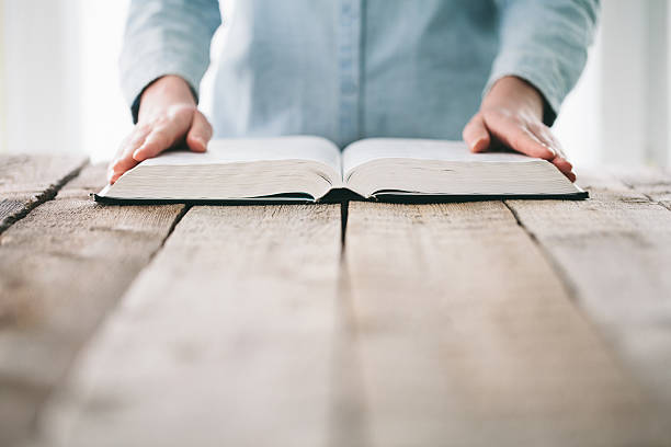 istock Woman reading and praying over Bible 629130030