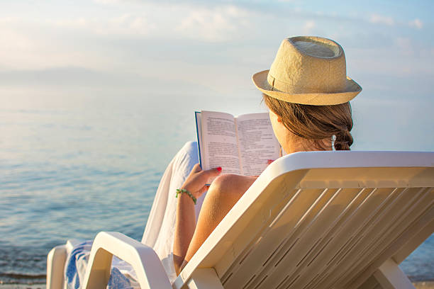 istock Girl reading a book in sunbed 629142620