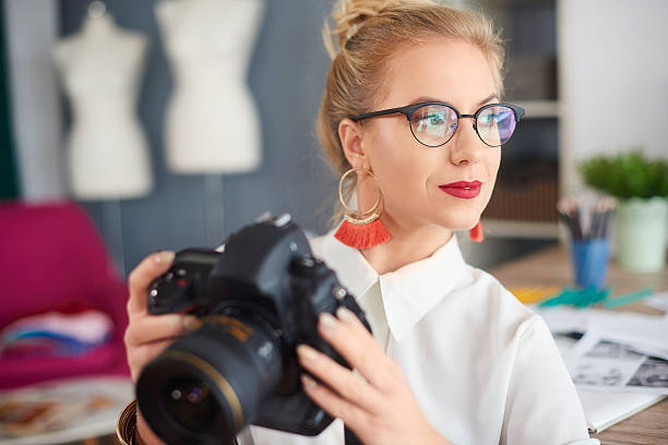 istock Thoughtful young woman holding camera 629143496