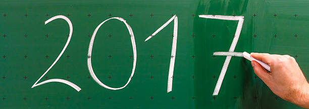 istock Man is changing year 2016 to 2017 on chalkboard. 629144310