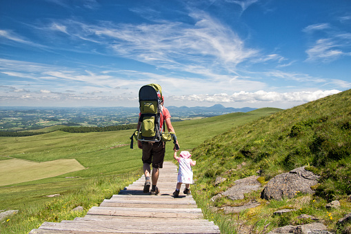 Father and his little daughter hiking together on trip on Massif Central in France