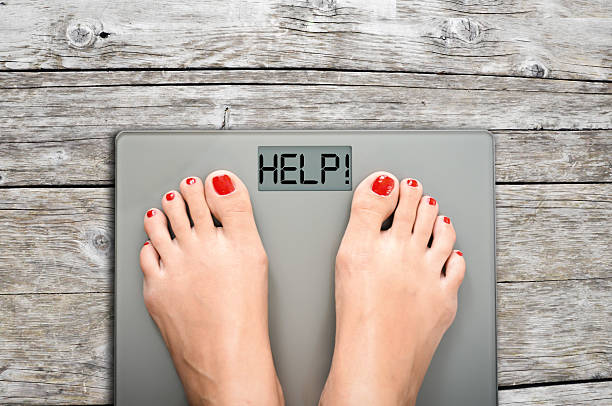 istock Help to lose kilograms with woman feet stepping on scale 629155796