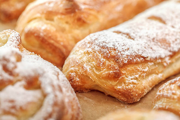 istock Row of freshly sweet buns with sugar powder, selective focus 629156184