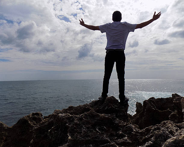 istock Man on the coast with open arms 629162352