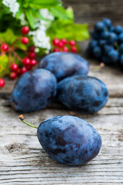 istock Plums with grapes on a wooden background. Top view. Close 629162572