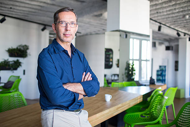 Successful senior businessman standing in office