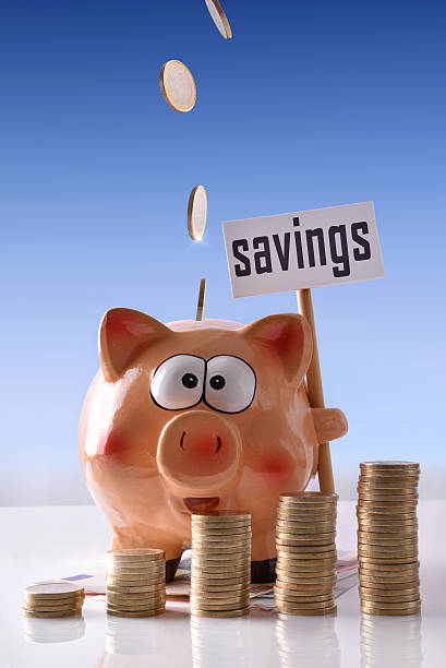 istock Coins falling on Piggy bank with blue background vertical 629170104
