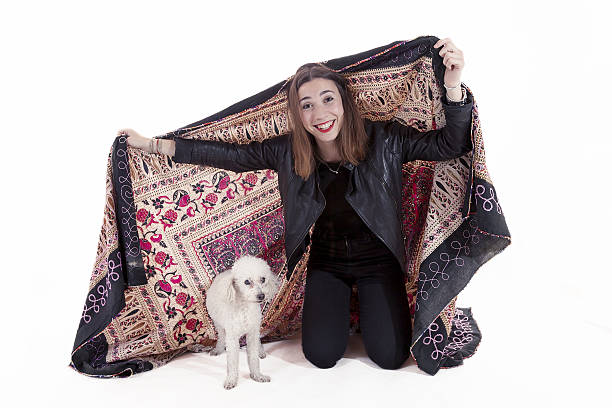 istock pretty girl plays with her dog under a blanket 629171228