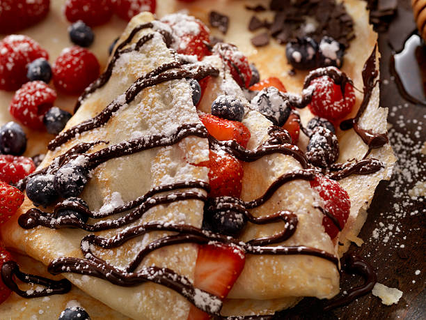 блинчики со свежими ягодами, шоколадным соусом и сахарной пудрой - griddle cake стоковые фото и изображения