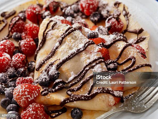 Crepes With Fresh Berries Chocolate Sauce And Powdered Sugar Stock Photo - Download Image Now