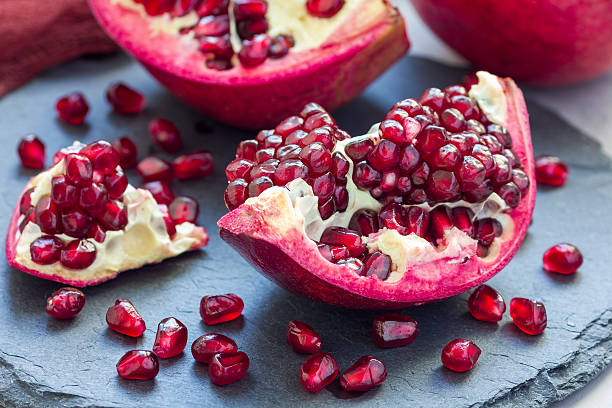 istock Fresh peeled red ripe pomegranate on gray slate board, horizontal 629172572