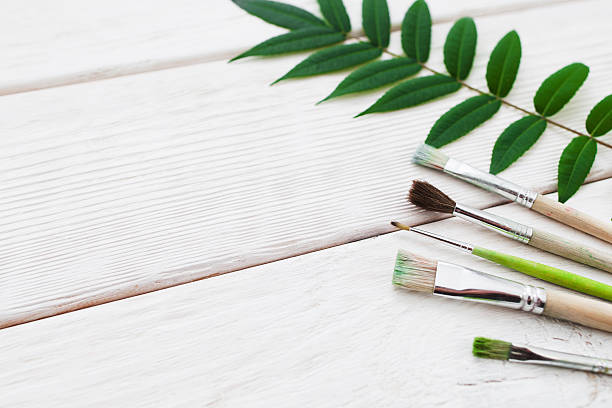 istock White wooden background with paintbrushes 629185678