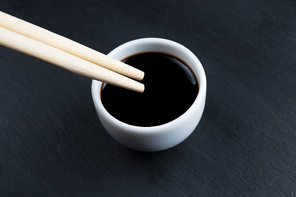 istock Soy sauce in small white bowl with chopsticks. 629187628