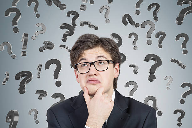 istock Businessman in suit and glasses and 3d question marks 629187878
