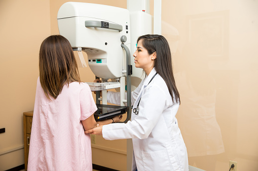 Médico que ayuda a la paciente a hacerse una mamografía photo