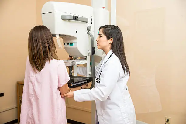 Photo of Doctor helping patient get a mammogram