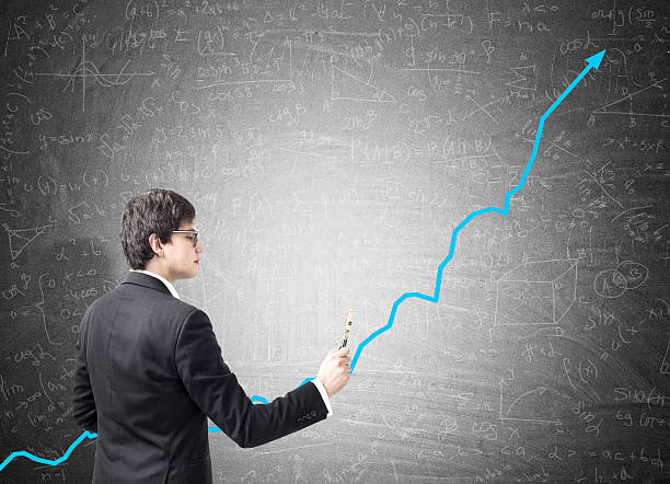 istock Businessman drawing a blue graph with a marker on blackboard 629189306