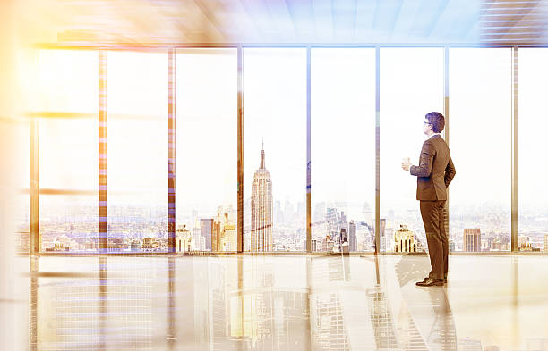istock Man with coffee in empty New York office 629189642