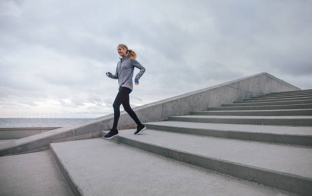 istock Healthy young woman running down on steps 629190158