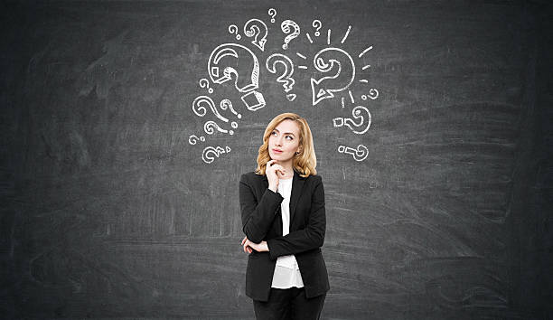 istock woman is standing near a chalkboard with quest 629190268