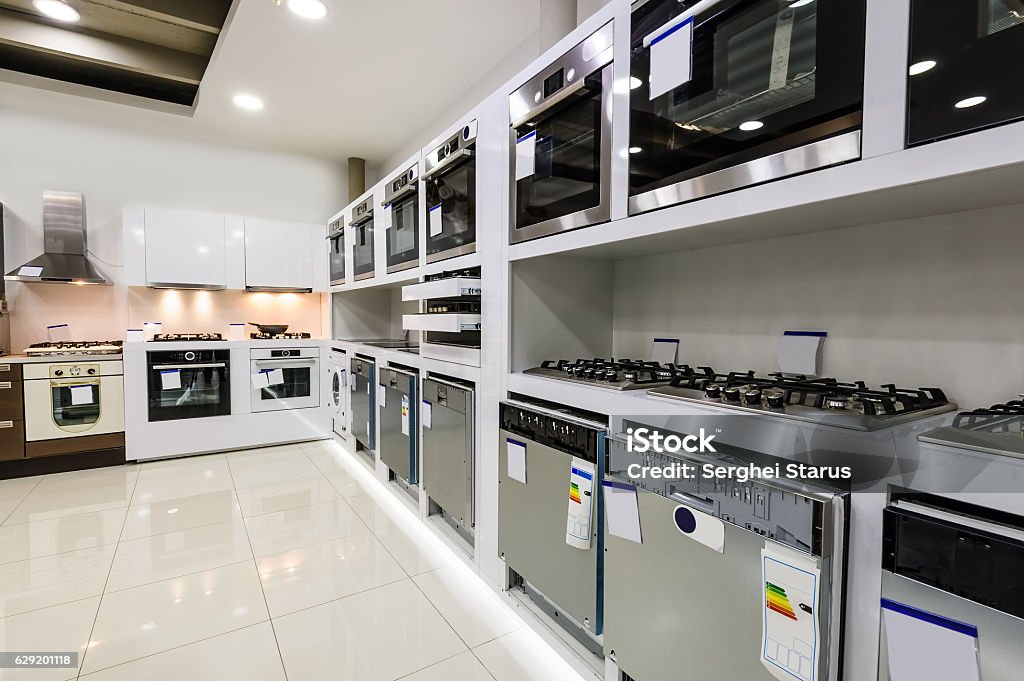 Home appliance in the store Gas and electric ovens, stoves and other appliance or equipment in the retail store showroom Electronics Store Stock Photo