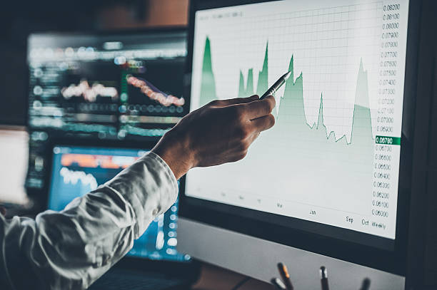 Analyzing data. Close-up of young businessman pointing on the data presented in the chart with pen while working in creative office risk stock pictures, royalty-free photos & images