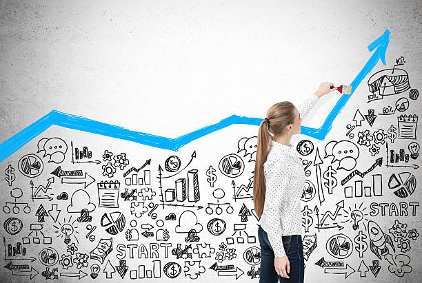 istock Woman drawing a blue graph on concrete wall with sketches 629202400