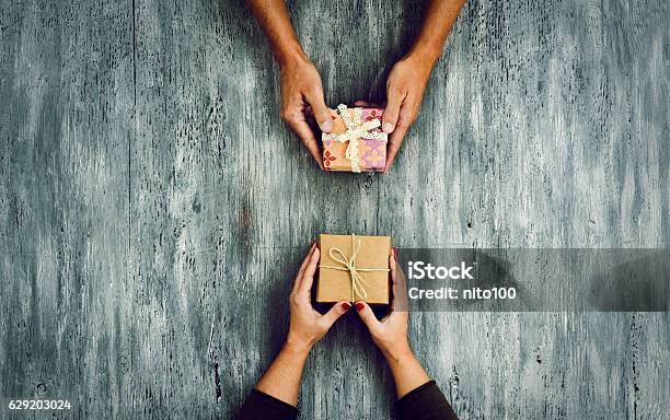 Woman And Man Exchanging Gifts Stock Photo - Download Image Now - Gift, Exchanging, Couple - Relationship