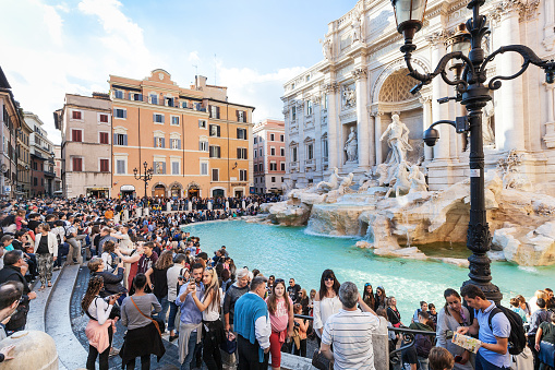 Rome, Italy - November 1, 2016: crowd of tourists and Trevi Fountain in Rome city. It is it is the largest Baroque fountain in the Rome and one of the most famous fountains in the world.