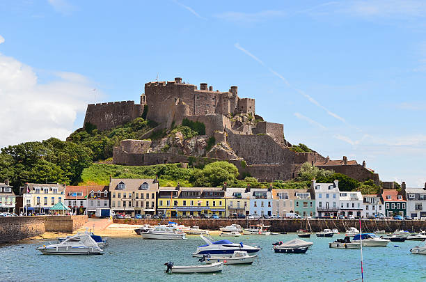 GB, Jersey Gorey, United Kingdom - June 9, 2011: Village with harbor and Gorey castle aka Mont Orgueil castle, landmark and tourist attraction on Jersey, one of the channel islands jersey england stock pictures, royalty-free photos & images