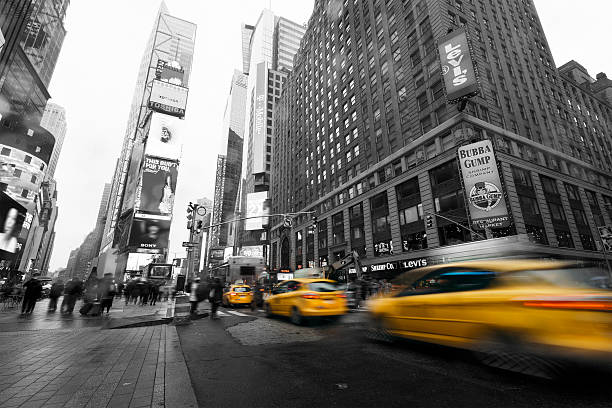 taxi in veloce a times square, new york - yellow taxi foto e immagini stock