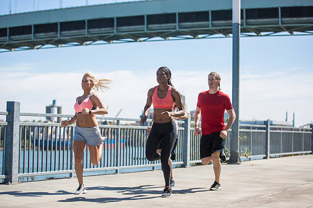 istock Diverse co-ed group of adults running along a pier 629211666