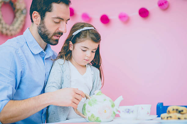 istock Ethnic father helping daughter pour tea in teacups 629212348