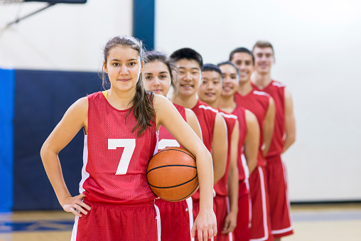 Diverse group of co-ed basketball players in a line