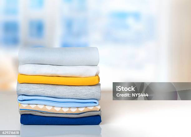 Stack Cotton Folded Clothes On Table Indoors Empty Space Stock Photo - Download Image Now