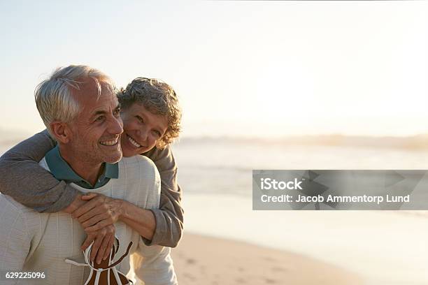 Senior Couple Having Fun At The Beach Stock Photo - Download Image Now - Senior Adult, Couple - Relationship, Retirement