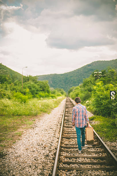 istock Man with retro suitcase standing on the railway 629227640