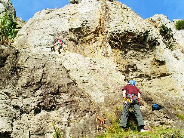 femme grimpant sur le rocher à tauranga, nouvelle-zélande. - mountain climbing rock climbing adventure incentive photos et images de collection