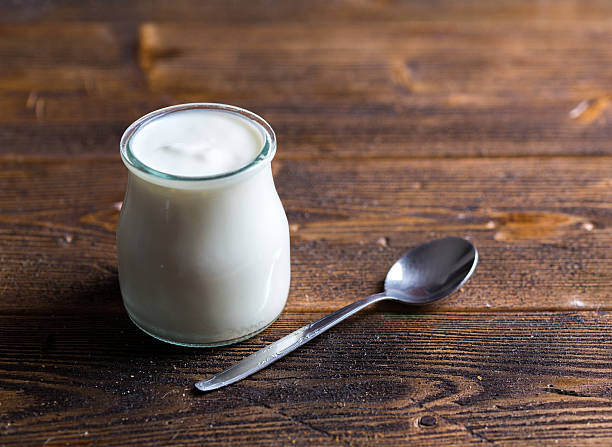 istock White yogurt in glass bowl on rustic table. 629229702